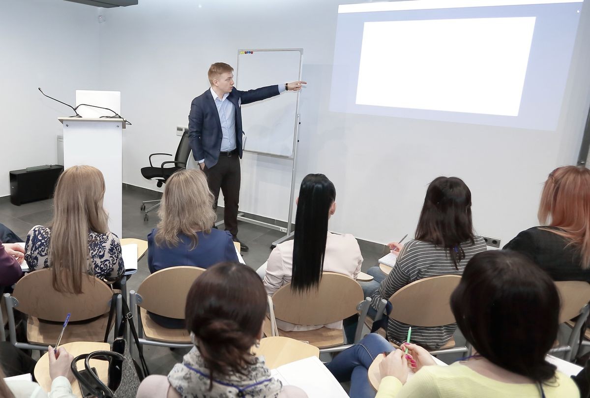 Speaker standing and lecturing on business conference in meeting hall